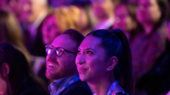 Two individuals attentively observing a talk.